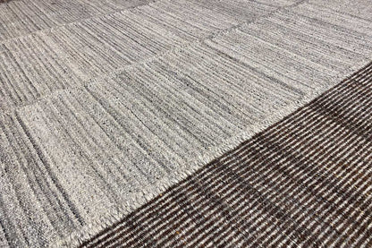 Detail of the carpet surface: fine woven texture in light gray with dark stripes