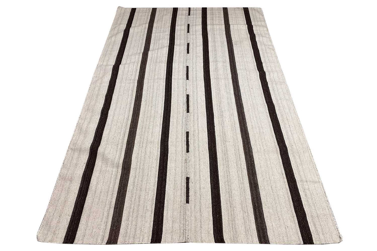 Kilim rug in light beige with long black lines, wide umbrella shape.