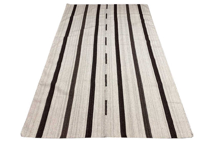 Kilim rug in light beige with long black lines, wide umbrella shape.