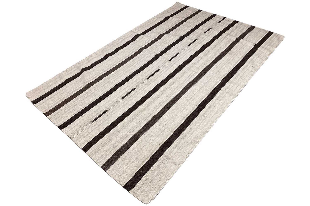 Kilim rug, laid at an angle: light base with dark stripes and narrow gaps.