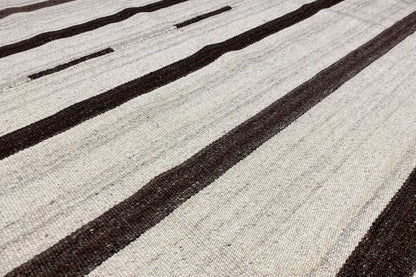 Kilim rug detail: woven texture with dark stripes and light spaces in between.
