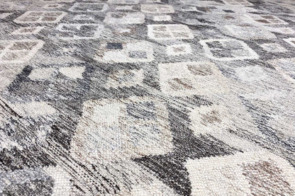 Close-up of the geometric flatweave pattern in light gray and cream with dark accents
