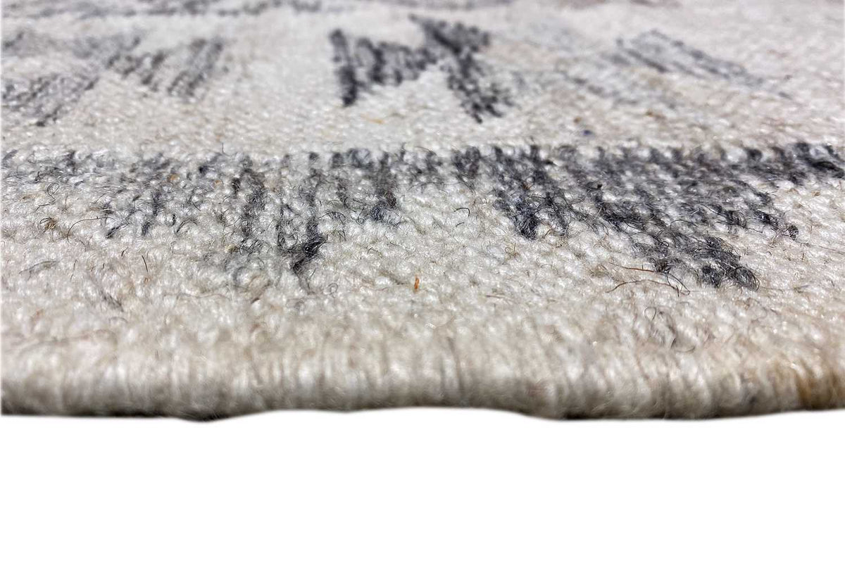 Close-up: kilim rug with fringe, light beige pile surface and dark blue patterns