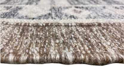 Close-up: kilim rug with dense fringe along the edge, blue-gray patterned surface