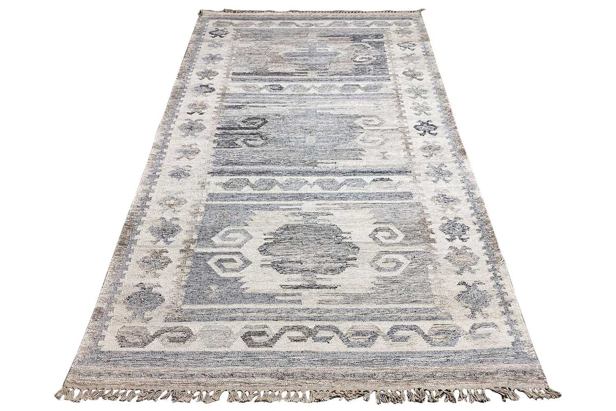 Rectangular kilim dhurrie rug with a geometric repeat, light gray-blue sections, and fringes