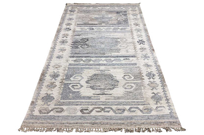 Rectangular kilim dhurrie rug with a geometric repeat, light gray-blue sections, and fringes