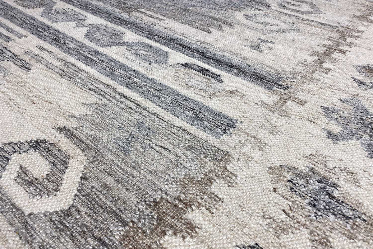 Detailed view of the Kilim-Dhurrie pattern: woven texture in light gray and blue tones