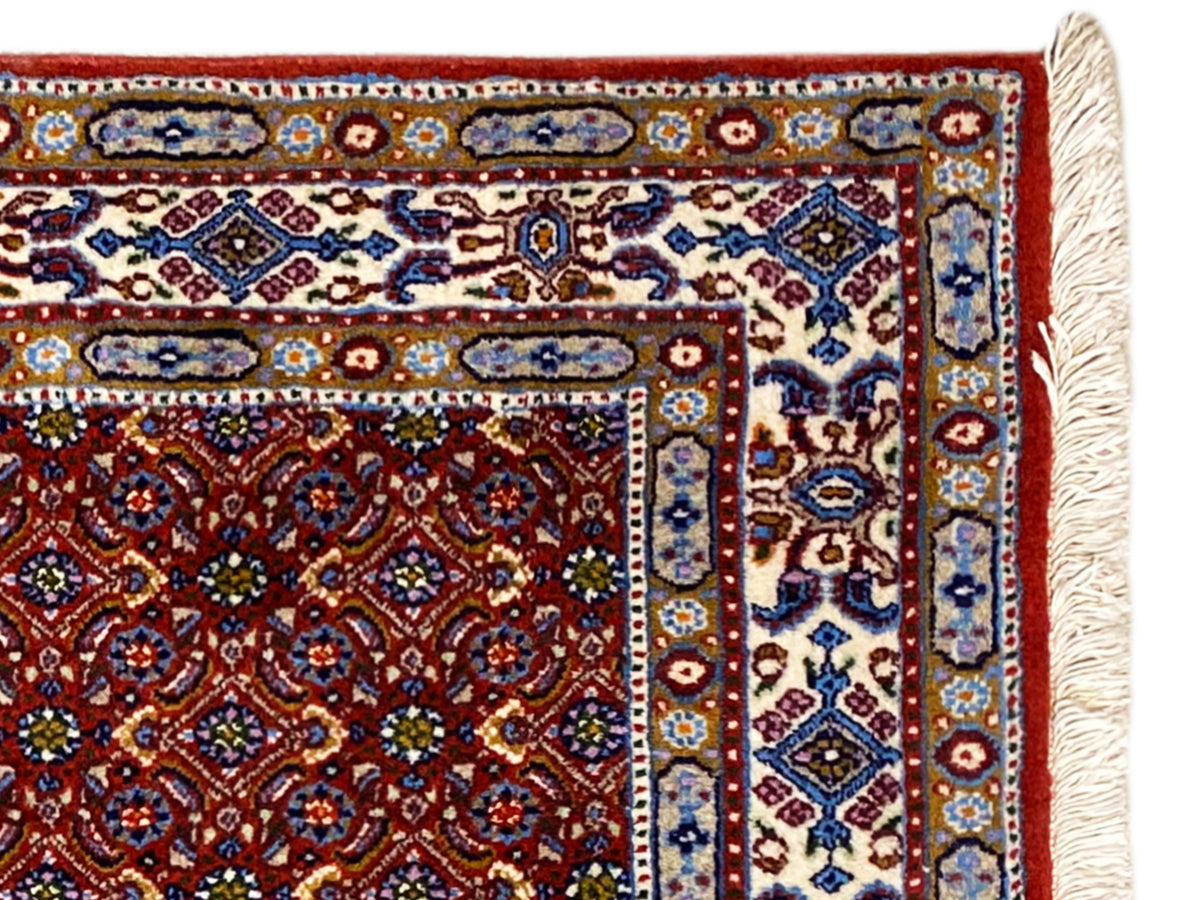 Oriental rug 132x122 cm, detailed view of the red pattern with blue decorative border