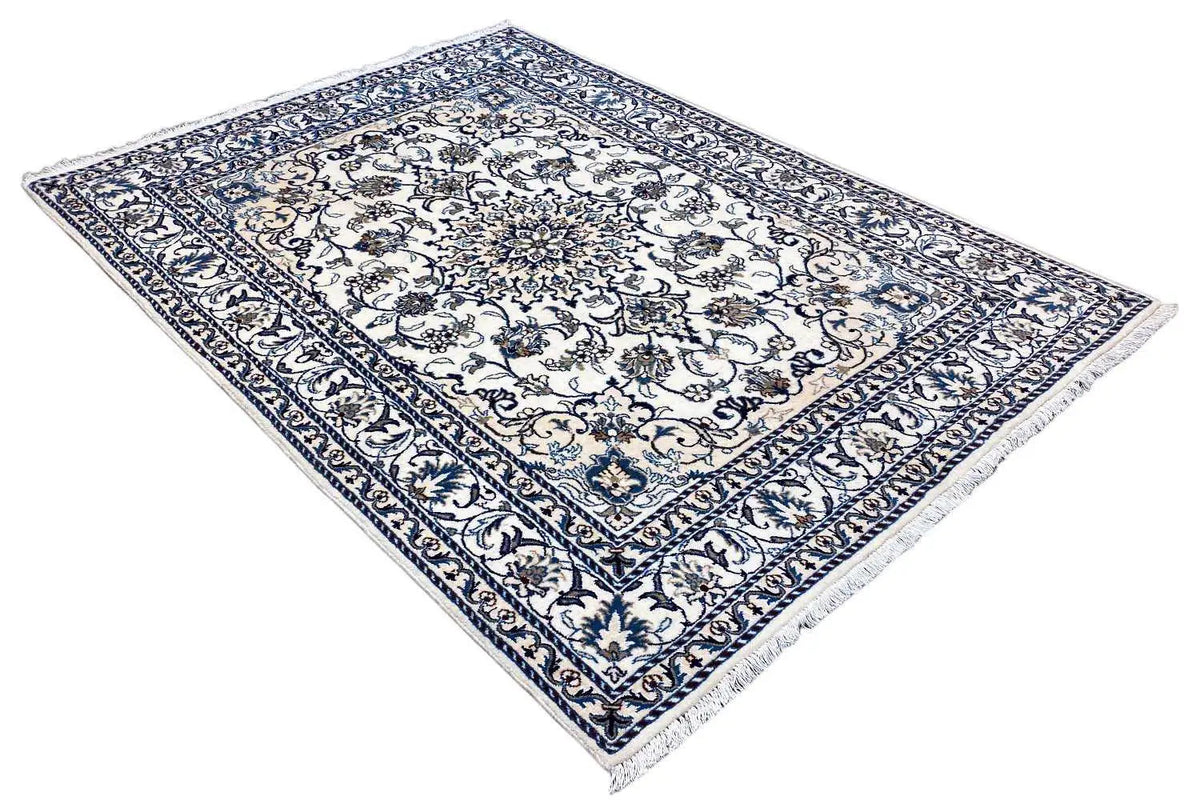 Rectangular Nain rug with a blue-and-white patterned field and wide border, fringes along the edges.