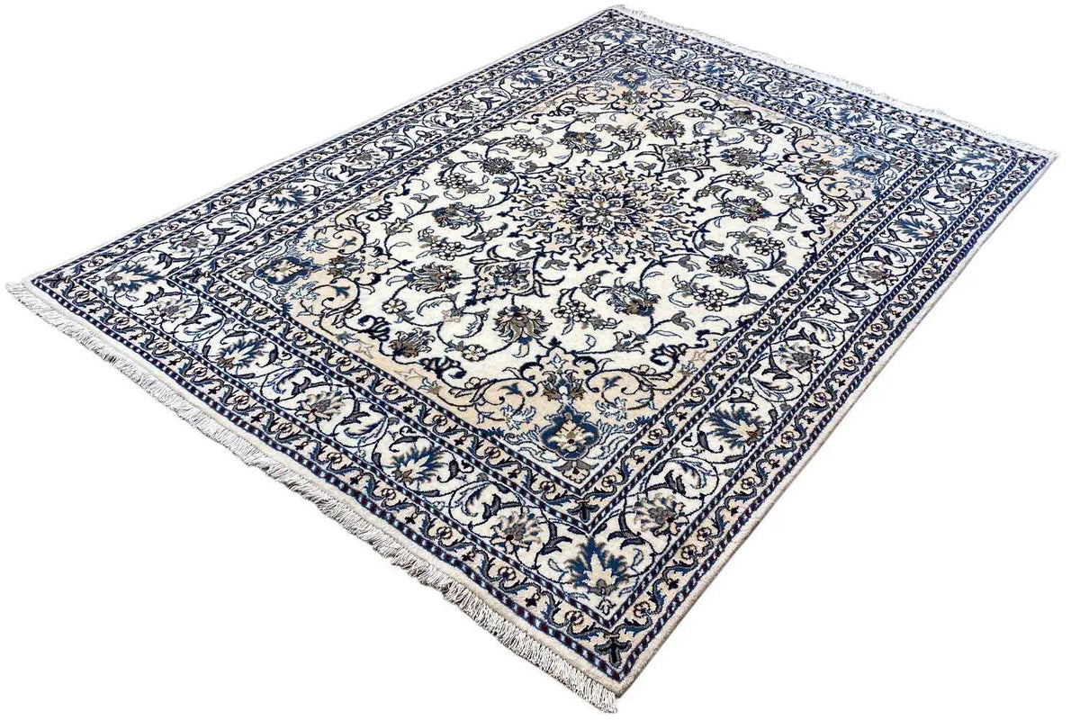 Rectangular Nain rug with blue-and-white floral patterns, a richly detailed border, and fringes.
