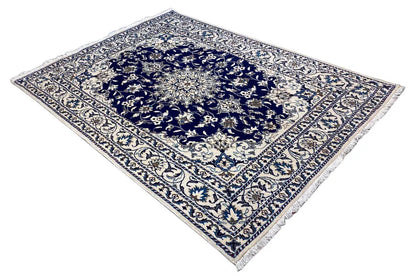 Nain rug with a central decorative medallion, blue background, and detailed border bands