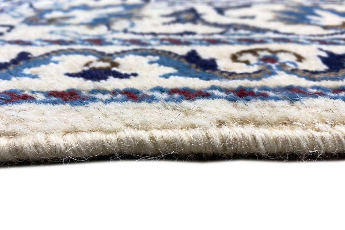 Close-up of the pile and selvedge of the Nain rug, multicolored pattern in blue and cream