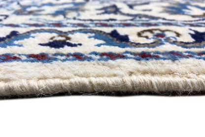 Close-up of the pile and selvedge of the Nain rug, multicolored pattern in blue and cream