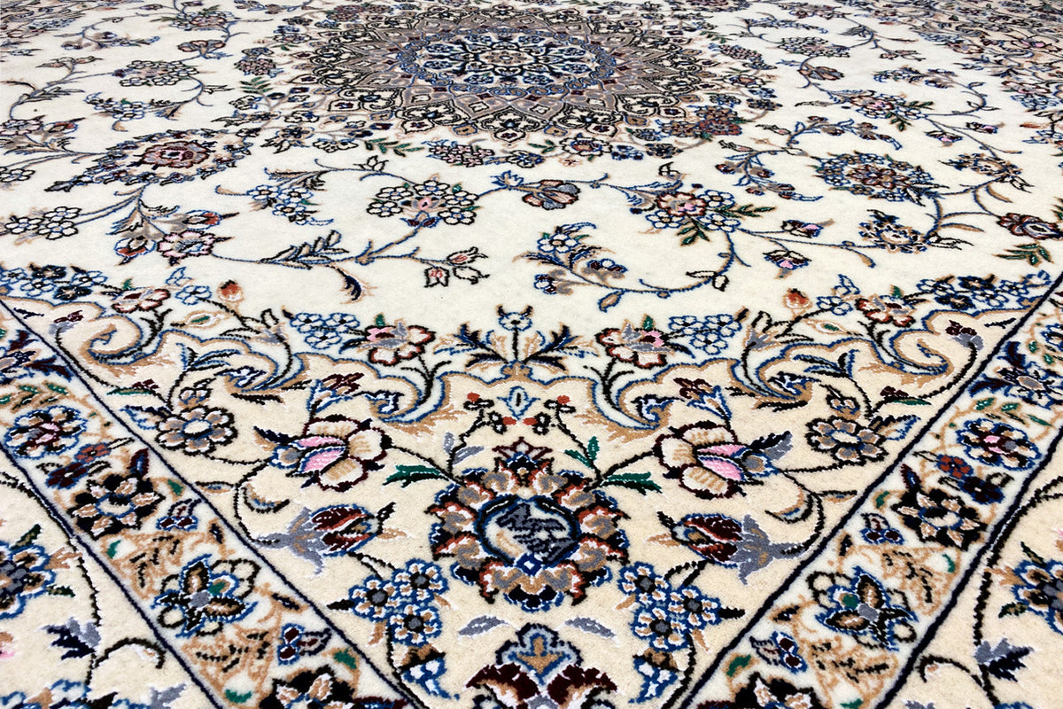 Close-up of a Nain rug: decorative floral and vine pattern in blue, beige, and brown
