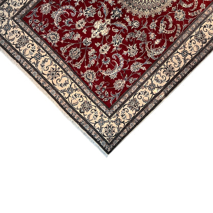 Nain wool rug at an angle: red field with detailed embellishments, surrounding cream-colored border