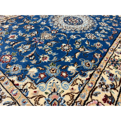 Close-up: Blue Nain rug with floral ornaments and a medallion in the center.