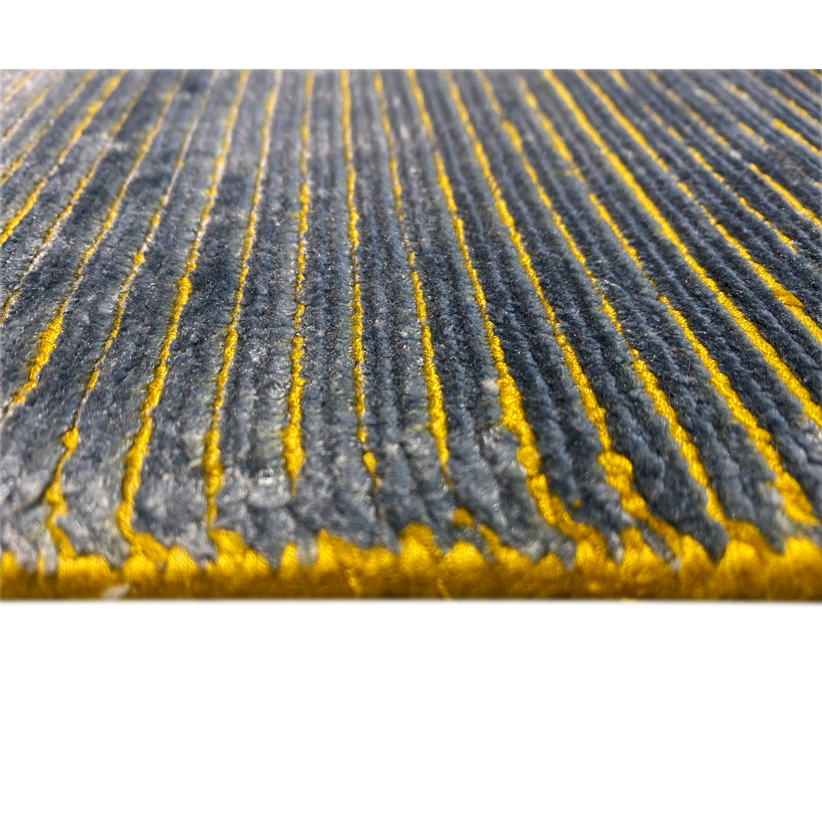 Close-up: Blue-gray carpet with long yellow lines and a fringed edge