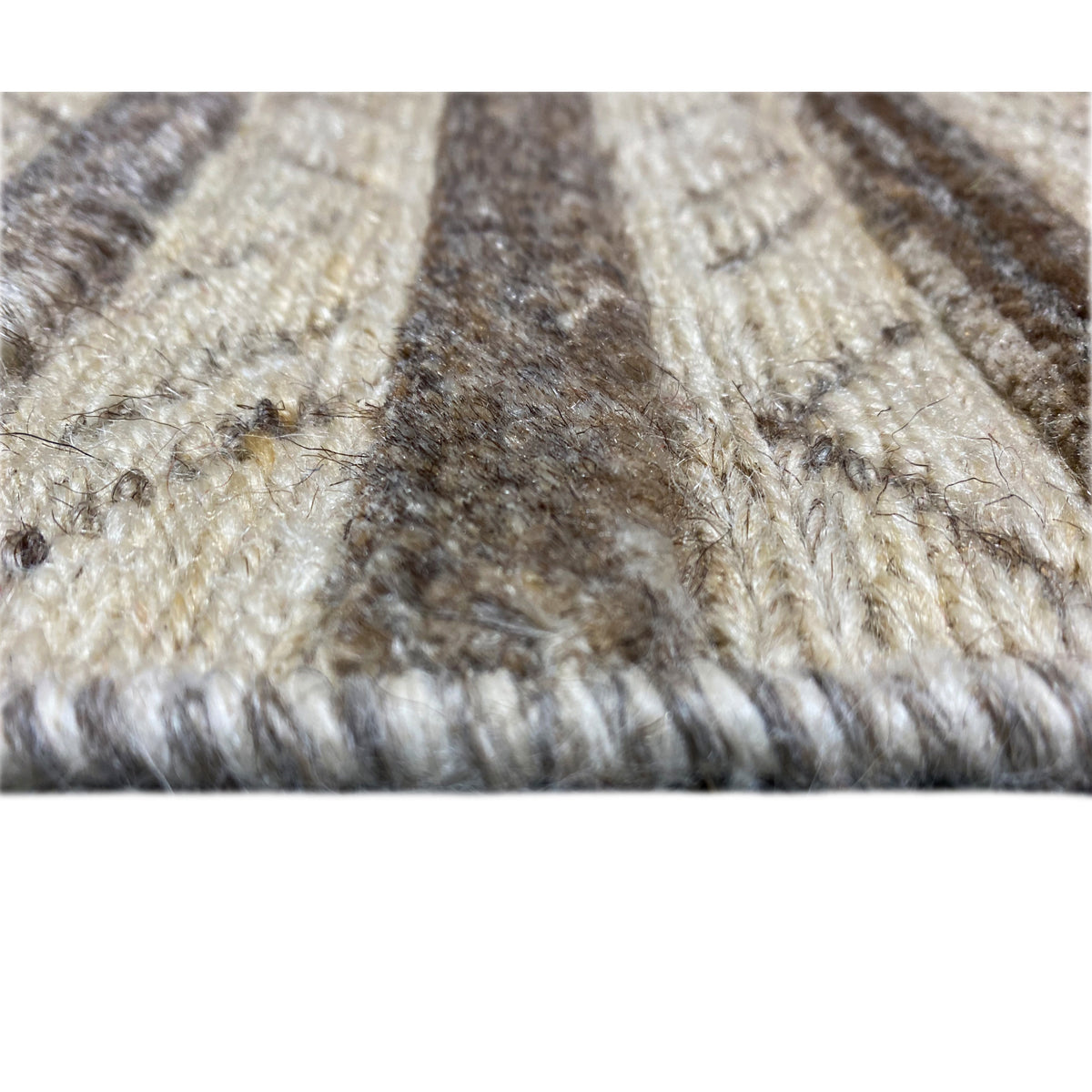 Texture details of the carpet: dense, plush material with beige and brown sections