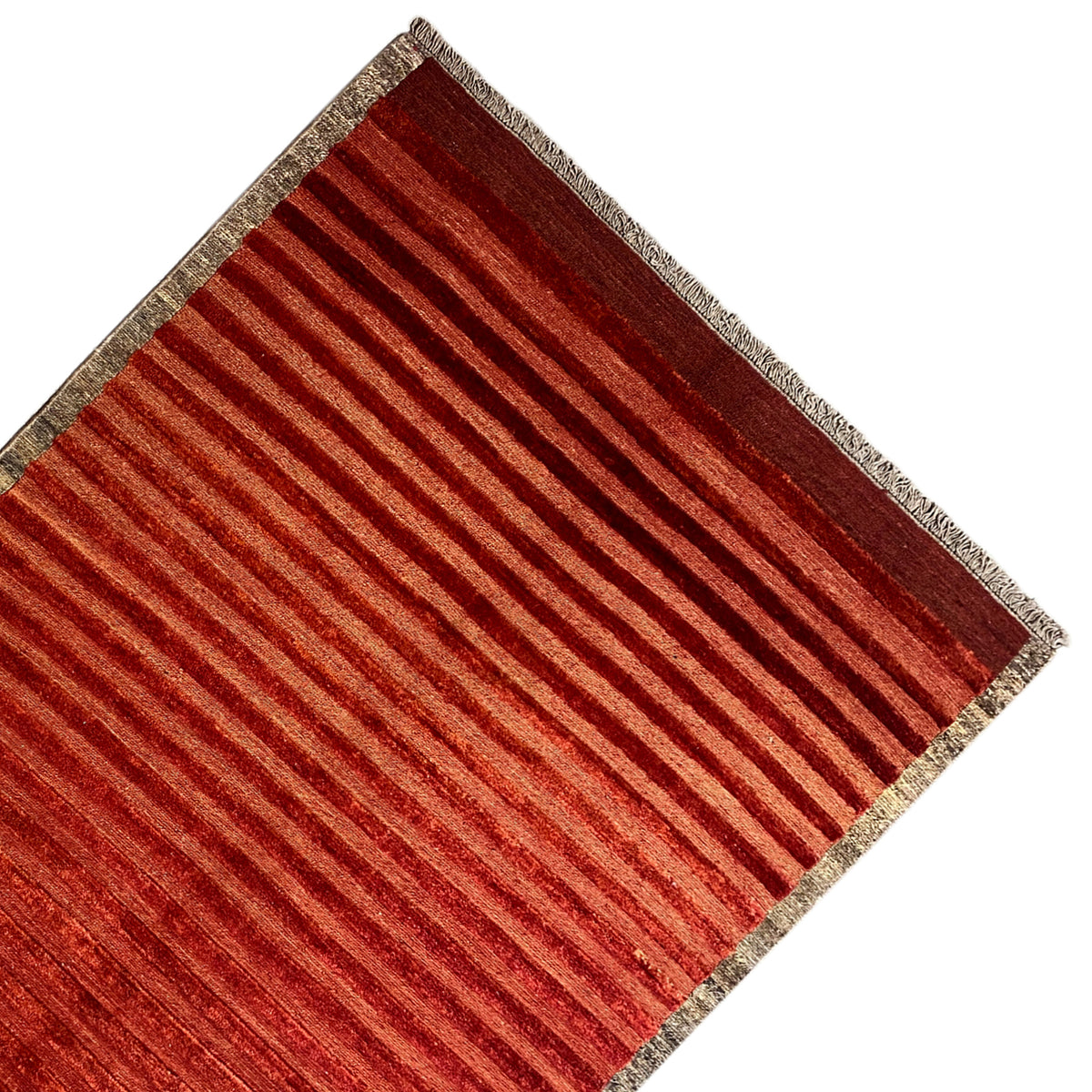 Rug from the side: reddish-brown stripes and a beige border with a bound edge