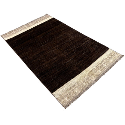 Rectangular Nimbaft rug, dark brown with a beige border and subtle surface texture
