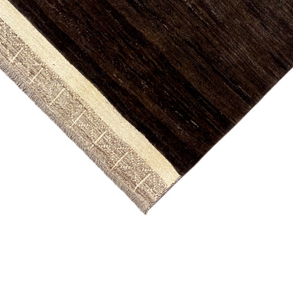Carpet edge with beige decorative trim and dark brown, striped pile texture