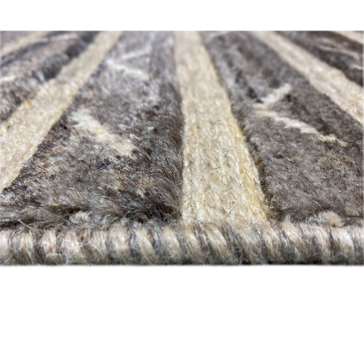 Close-up of carpet pile with a visible texture and short fibers in gray and beige