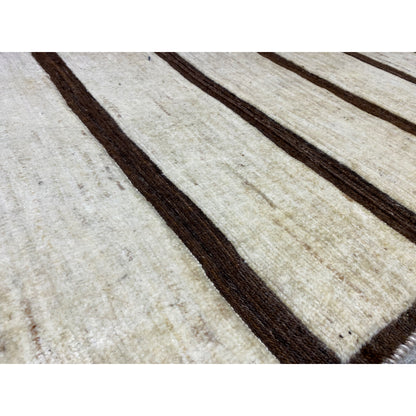 Detail of the Nimbaft rug: woven texture with beige areas and brown stripes