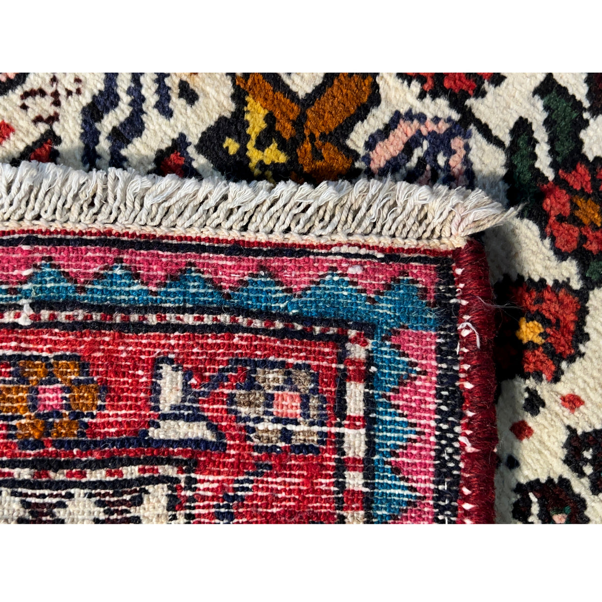 Poshti rug edge detail with fringed edging and multicolored border