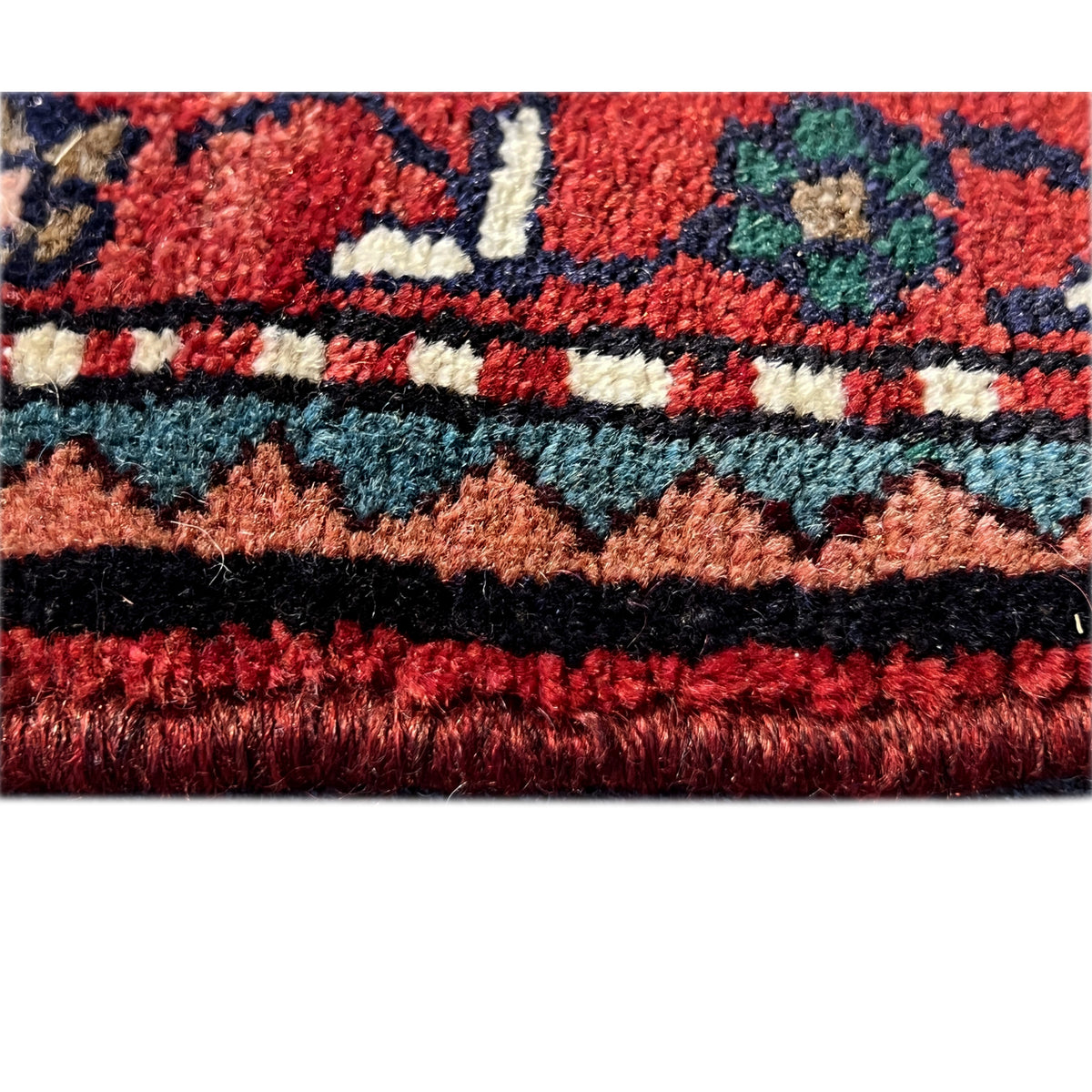 Poshti rug detail with pile height and fringed edge, shades of red and blue