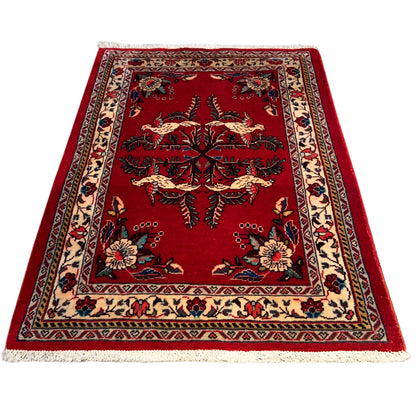Portrait-oriented red carpet with a central tree and animal motif and a colorful border