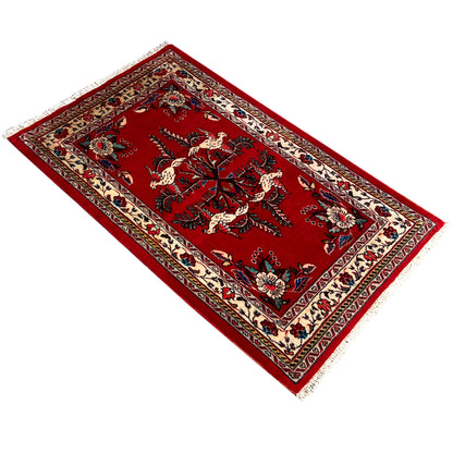Red carpet with a central tree and animal motif, ornaments in cream, blue, and green