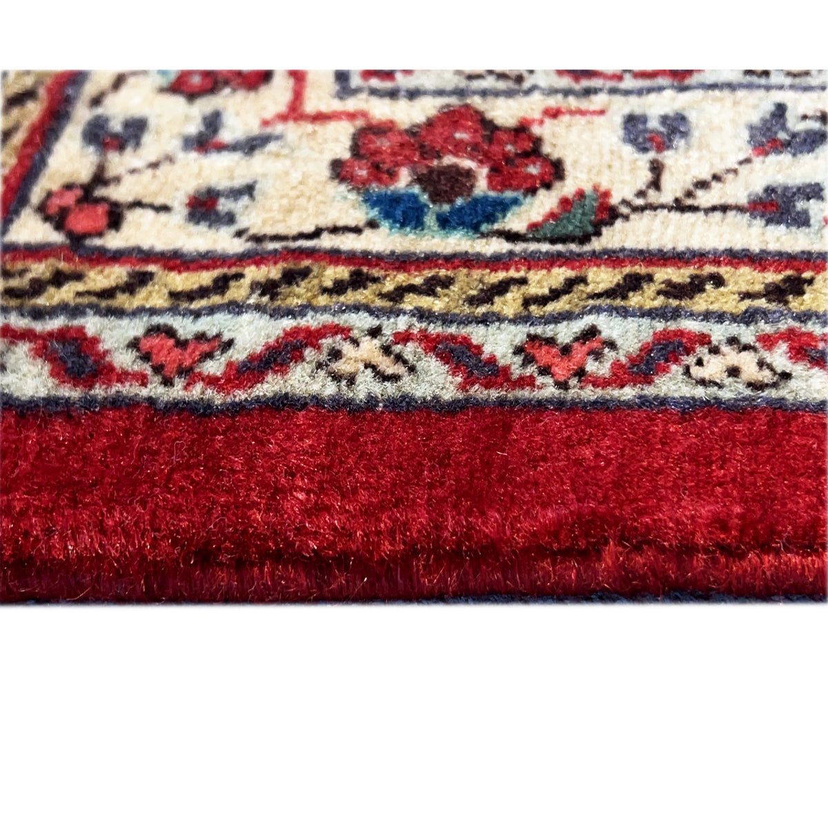 Carpet edge: red pile with a striped cream-colored border and blue-red ornaments