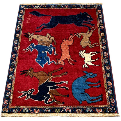 Wool rug with a red background, many animal depictions, framed in blue