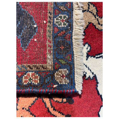 Wool rug detail at the fringe and border edge, red field with animal ornamentation