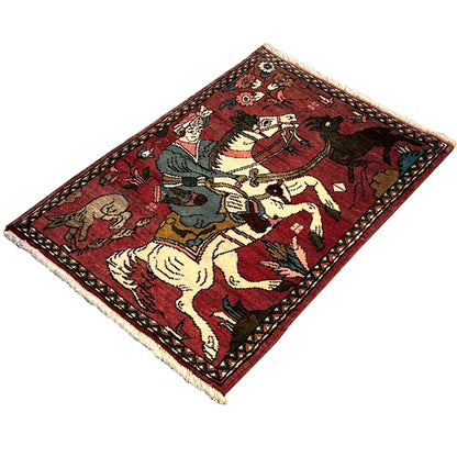 Red Hamedan rug with a central equestrian motif and a multicolored ornamental border frame