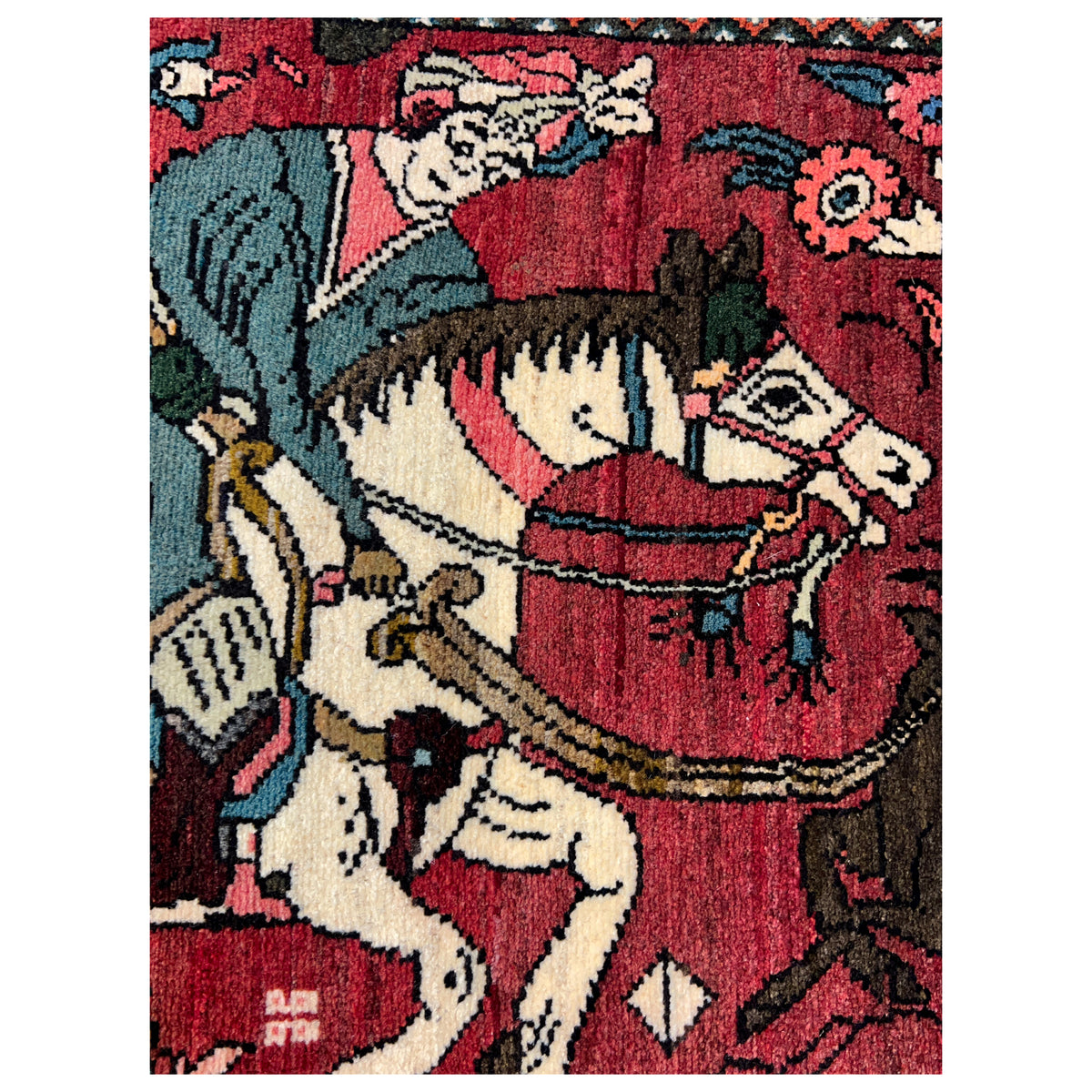 Close-up: red multicolored Hamedan carpet with a horse and rider motif in the patterned field