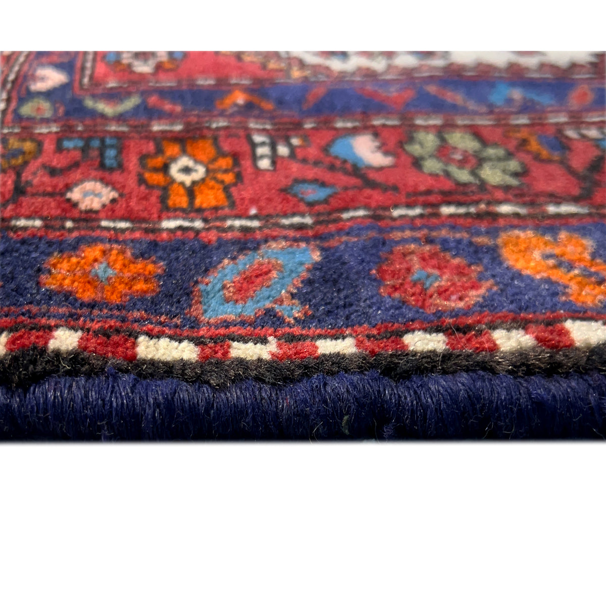 Close-up of the lower edge with a dark hem, colorful patterns, and dense fringes