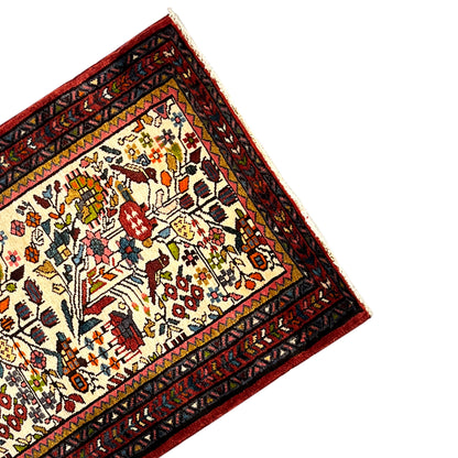 Close-up of the edge of the Poshti rug: red decorative band with ornaments on cream