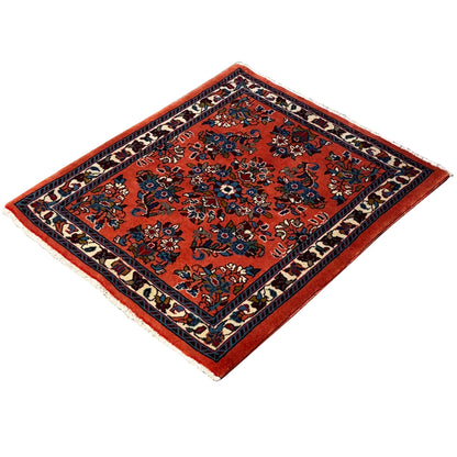 Orange rug with a dark border and floral patterns, square
