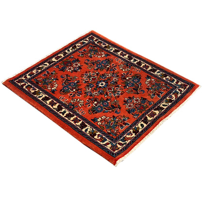 Square rug with an orange pattern and dark blue border