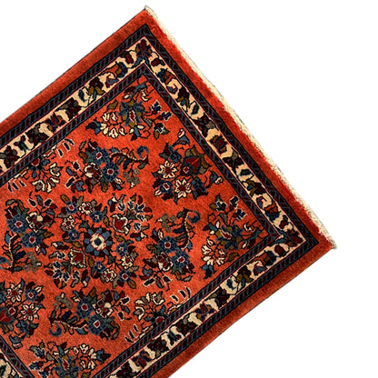 Carpet detail: orange base with blue-black ornaments and a narrow border