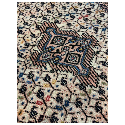Detailed view: Beige Poshti rug with blue and red accents in the pattern