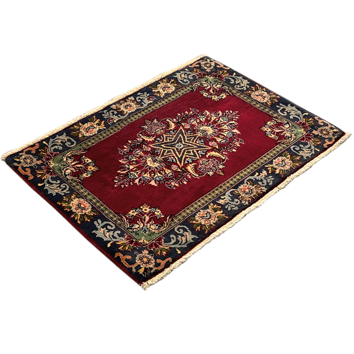 Rectangular rug with a red central field, blue-black ornamental border, and fringe