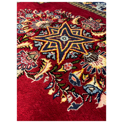 Red Poshti rug close-up with blue star and floral ornament, 93x66 cm
