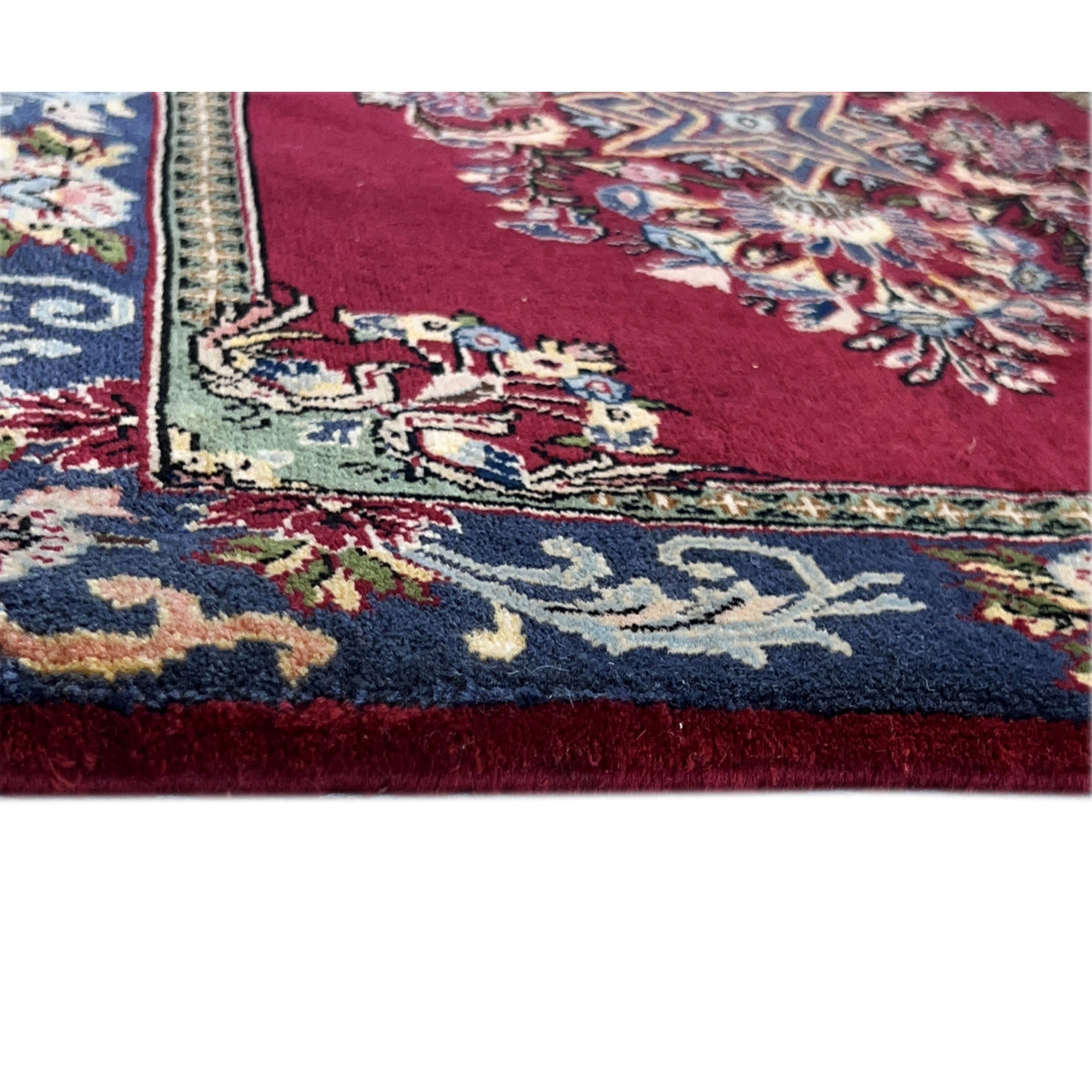 Detail carpet: red pile with multicolored floral ornaments along the edge