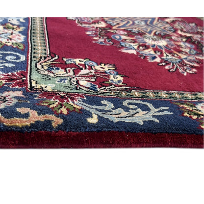 Detail carpet: red pile with multicolored floral ornaments along the edge