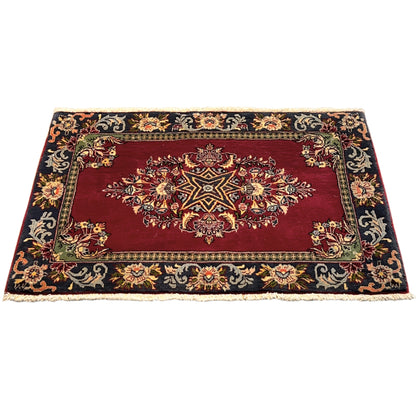 Rug with a red center, a dark ornamental border, and a delicate border stripe