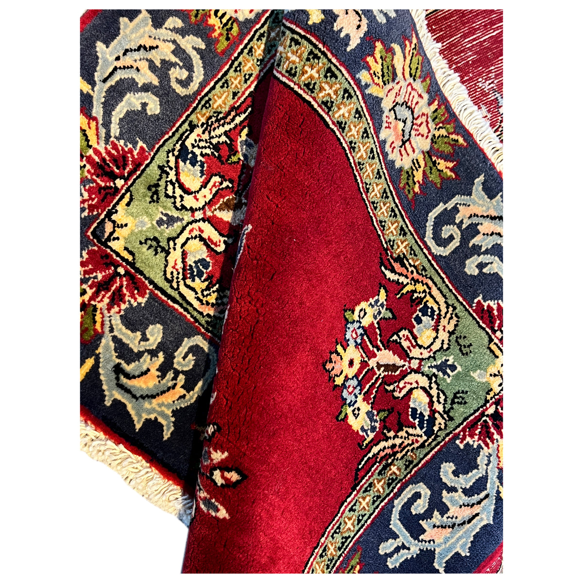Carpet viewed from the side: red central field and embroidered blue border