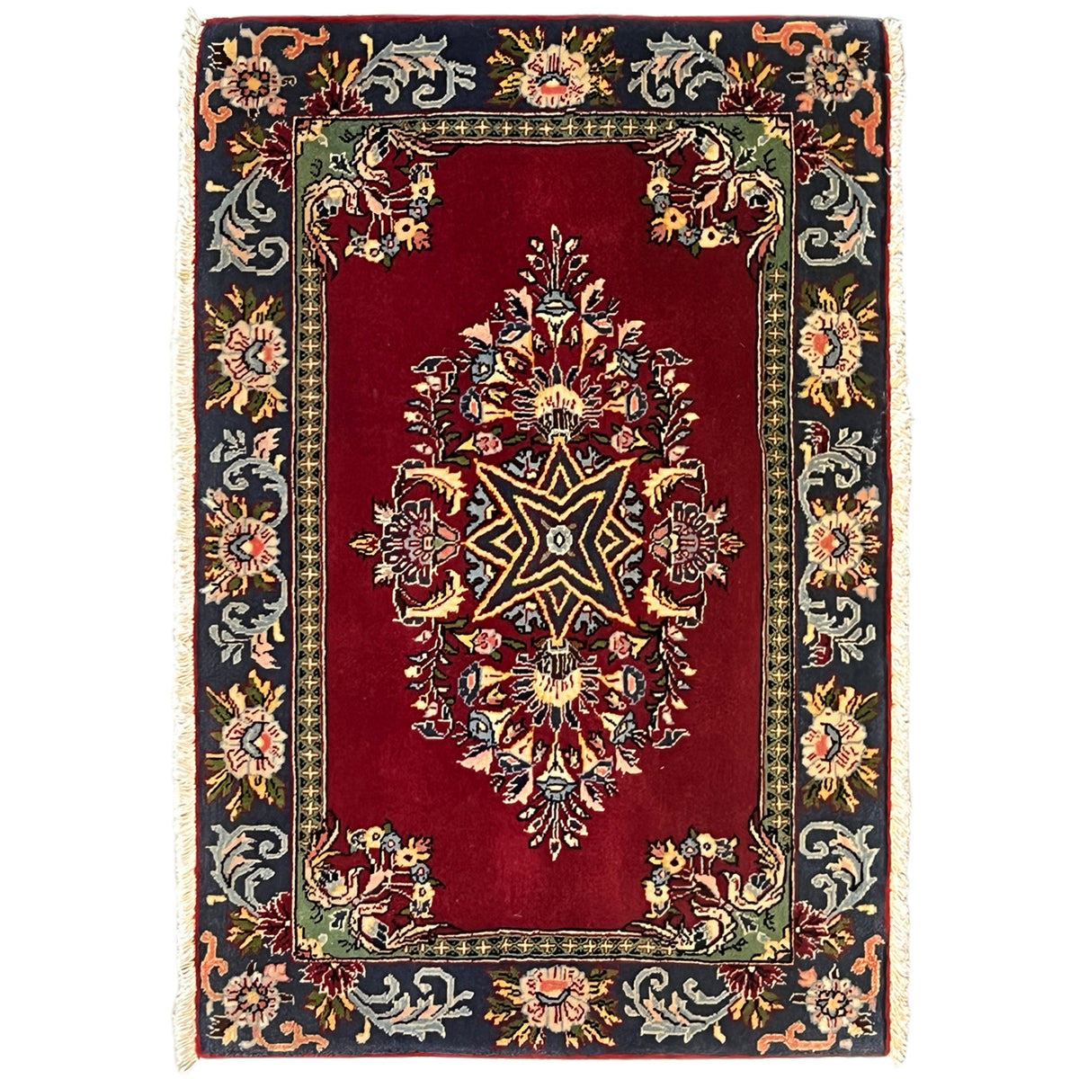 Red rug with an ornamental pattern and dark border, rectangular, with fringes