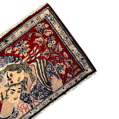 Corner of a red rug with fringes and an intricately detailed decorative border